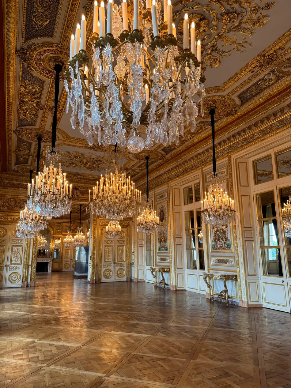Gold and crystal chandeliers lighting a gallery inside the Hôtel de la Marine
